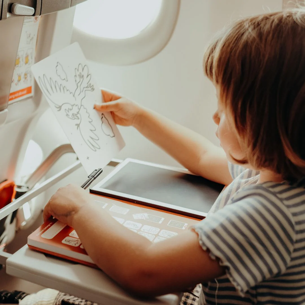 Child using a tablet on an airplane tray table
