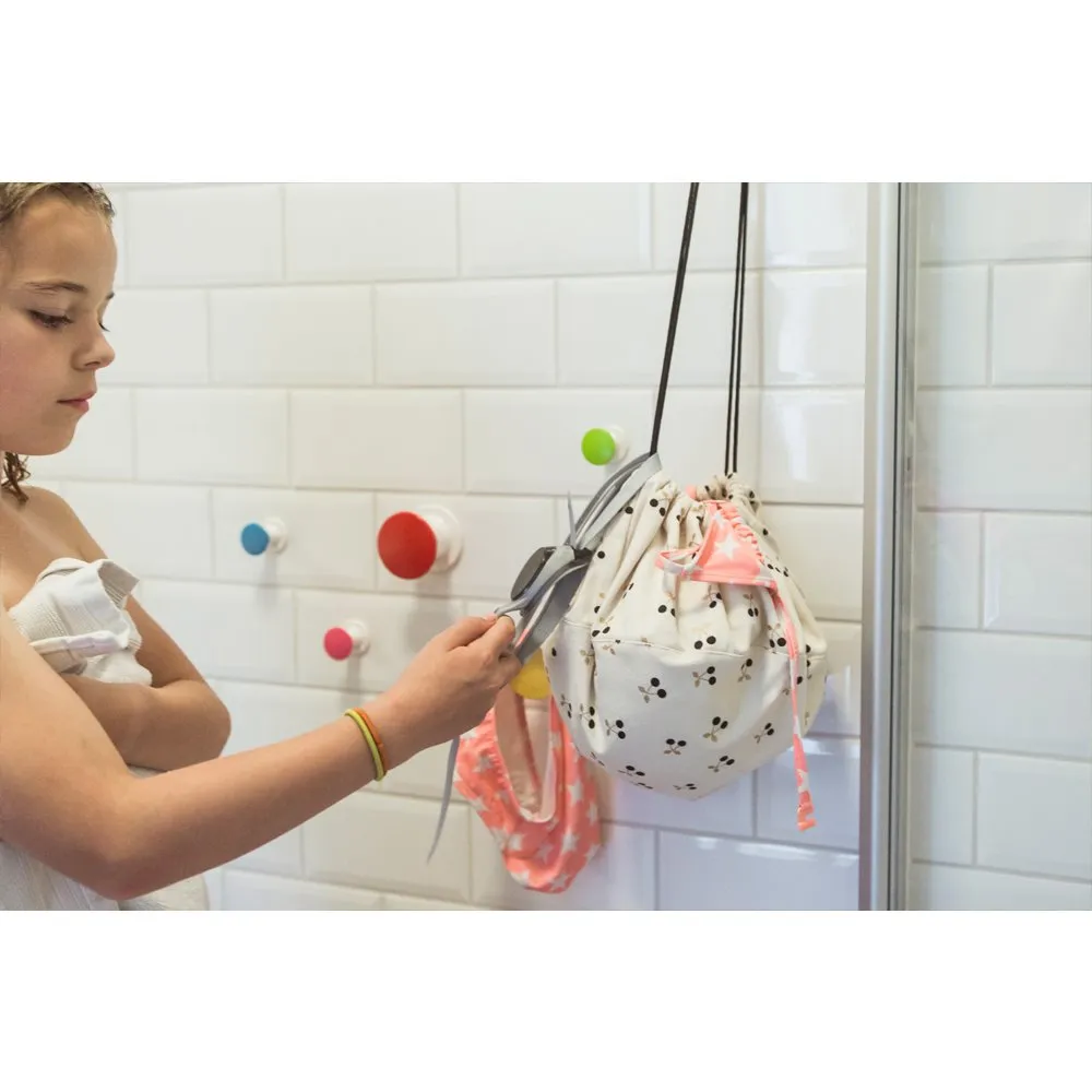 Child in a bathroom using scissors to cut a drawstring bag.