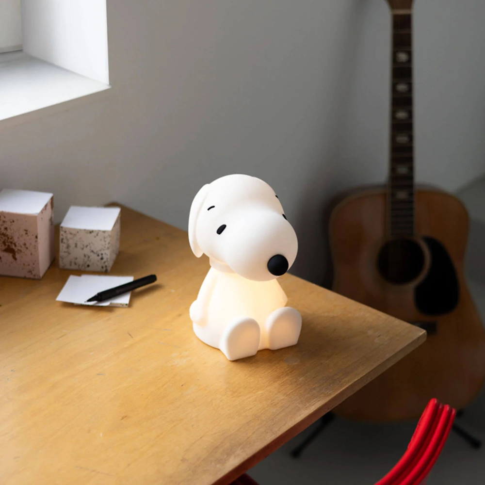 Dog-shaped lamp on a wooden table with a guitar in the background