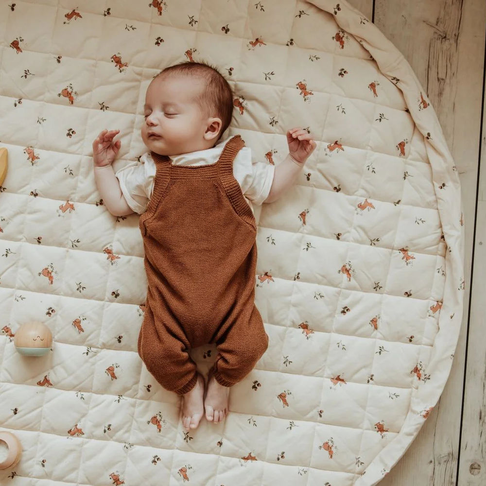 Newborn baby asleep on a nomad soft playmat