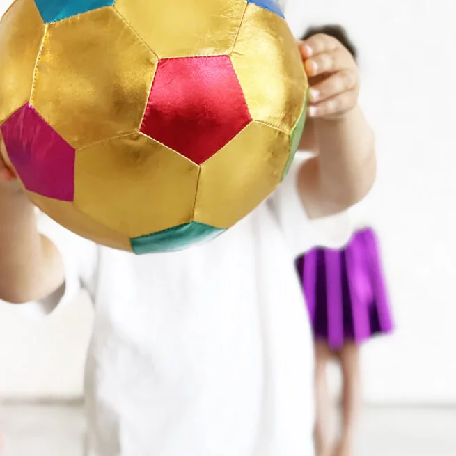 Colorful ball held by a child with a blurred background