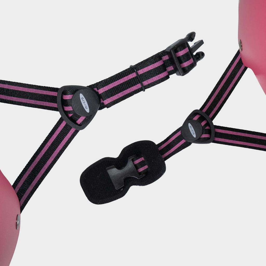 Close-up of the pink and black adjustable straps and buckle on the Micro Eco helmet