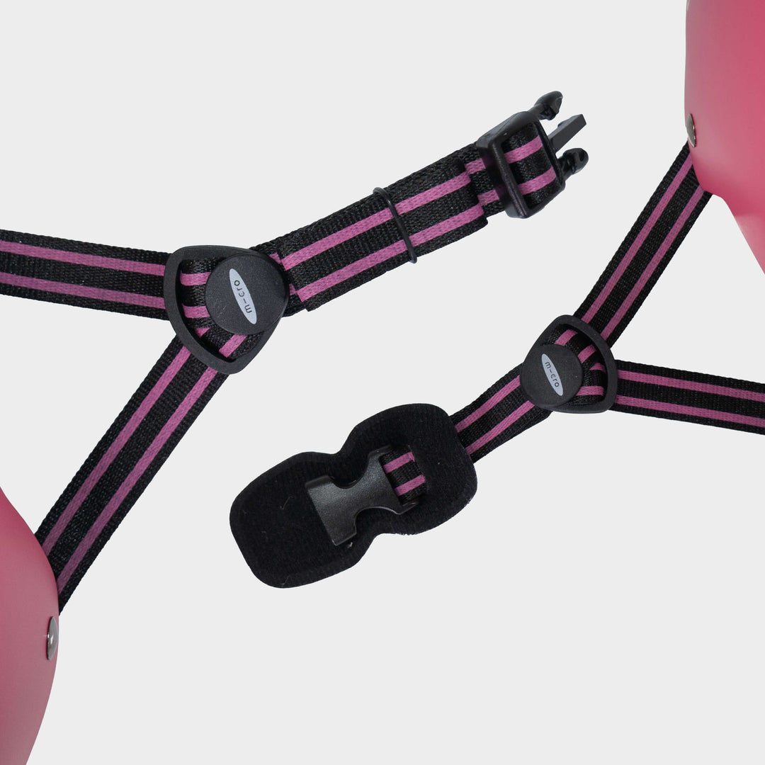 Close-up of the pink and black adjustable straps and buckle on the Micro Eco helmet
