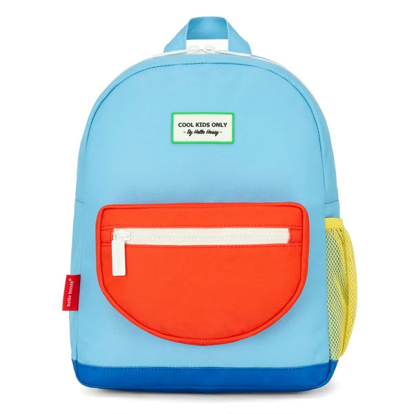 blue backpack with red pocket and yellow mesh pocket in a room.